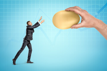 Businessman drawn to a giant golden egg