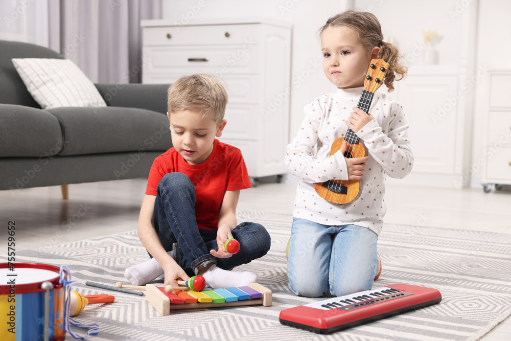 Wall mural Little children playing toy musical instruments at home