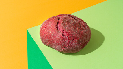 Beetroot purple bun on minimal green background.
