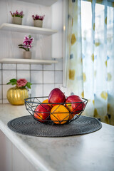 Kitchen Concept: Metal Bowl with Fresh Oranges and Apples. Vibrant and colorful fruits arranged in...
