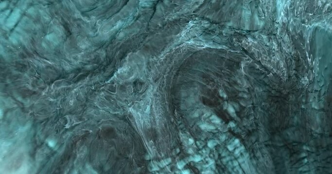 Turquoise dark paint colors spread marble stains, close up. Dynamic abstract natural blue ink pattern. Flow plain black aquamarine fluid texture. Deep sea color splash liquid. 4k vertical moving video