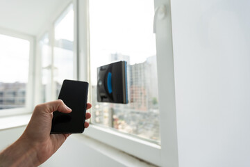 Modern window washer robot performs work on a dirty window. Cleaning the house with smart devices....