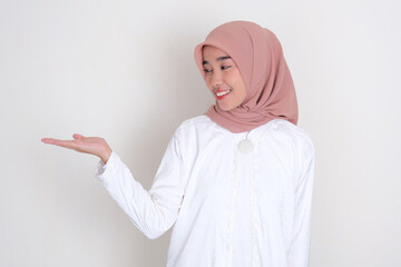 Moslem Asian woman smiling and looking to her facing up palm hand