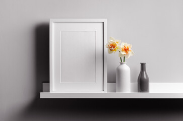 Blank vertical frame mockup on shelf with flowers
