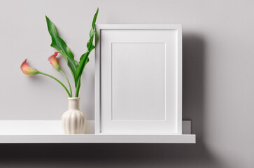Portrait white frame mockup on shelf with flowers