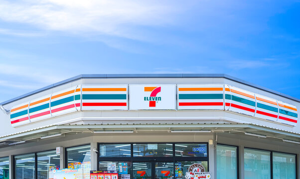 Samut Sakhon, Thailand - March 11, 2024 : Front view of modern 7 Eleven Convenience Store Building with geometric polygonal flat slab roof against blue sky background