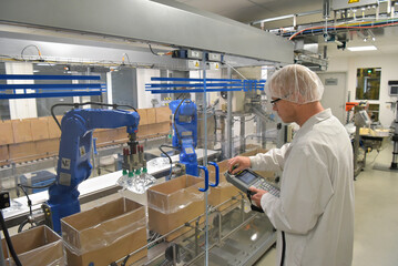 medical products manufacturing in a modern factory - worker operates modern industrial plant - obrazy, fototapety, plakaty