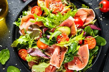 Green vegetable salad with snoked ham and sesame. Top view with space for text. Macro.