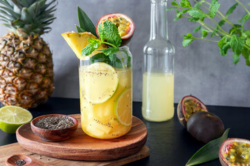Fototapeta premium Tropical pineapple cocktail with passion fruit or maracuya and chia seeds topped with fruit.
