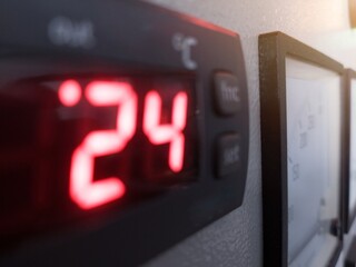 Close up the blurred digital temperature control on the panel power control boiler system.