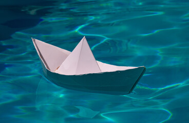 Paper ship , origami paper ship sail. Paper boat on the sea water background. Dreaming traveling.