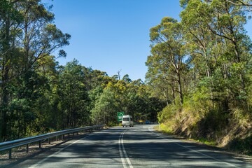 tourist traveling in a caravan exploring nature driving on a raod in the forest Cars Driving on a highway road, in australia