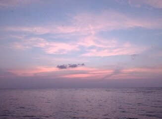 Cloudscape, Colored Clouds at Sunset near the Ocean on a Blue Sky