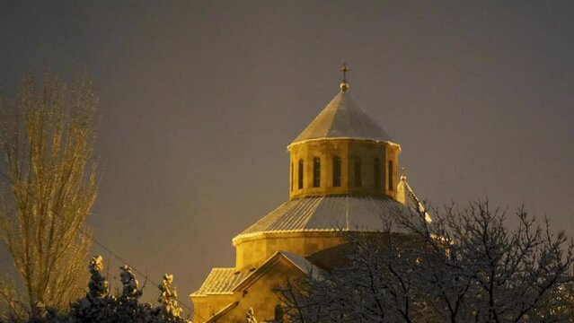 Beautiful Surb Sargis (Saint Sarkis) Armenian apostolic church covered with snow during a winter evening in Nor Nork district in Yerevan, with foreground trees, zoom in, uhd, 4k, 3840, 2160