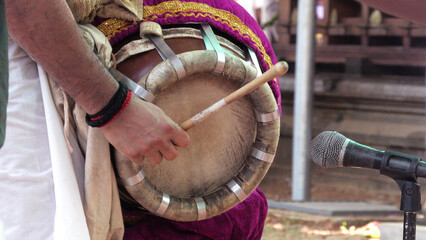 An artist playing Thavil, a South Indian percussion musical instrument