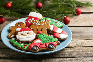 Obraz premium Different tasty Christmas cookies and fir tree branches on wooden table, closeup. Space for text