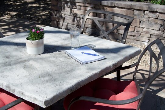 Outdoor Table With Glass  of Water and Notebook