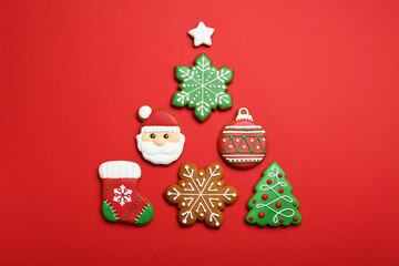 Different tasty Christmas cookies on red background, flat lay