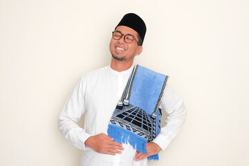 Moslem Asian man touching his stomach with relieved expression