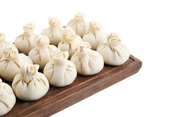 Wooden board with uncooked khinkali (dumplings) isolated on white. Georgian cuisine