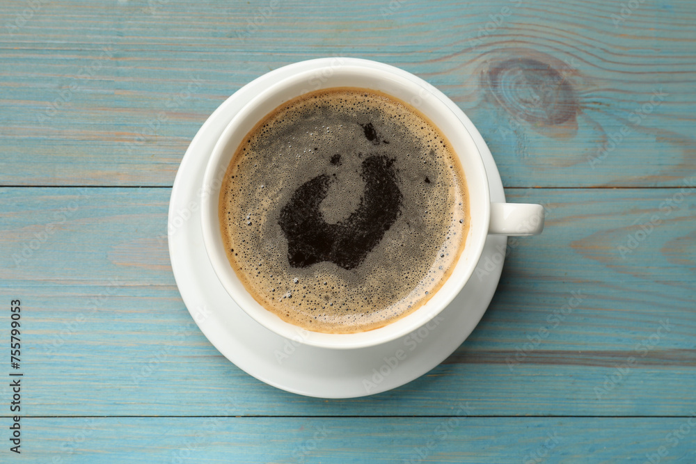 Sticker Cup of aromatic coffee on light blue wooden table, top view