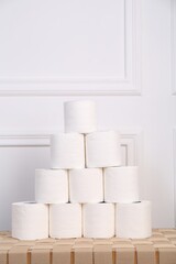 Pyramid of toilet paper rolls on wicker table