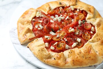 Tasty galette with tomato, thyme and cheese (Caprese galette) on white table, closeup