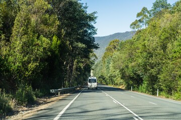 tourist traveling in a caravan exploring nature driving on a raod in the forest Cars Driving on a highway road, in australia