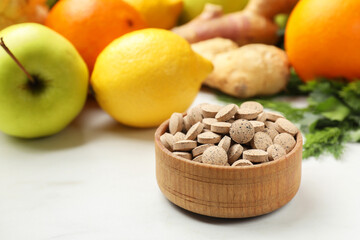 Dietary supplements in wooden bowl and products on white table, closeup. Space for text
