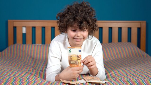Boy Child 9 years old count money 50 euro banknotes cash - save money in childhood and learn economics