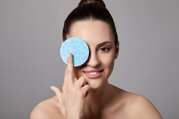 Skin care. beauty and spa. Beautiful woman with nude makeup at grey background with cleaning sponge. Cosmetology