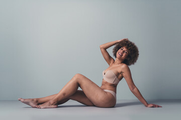 Unretouched photo of body positive girl smiling posing for photo session in brand new lingerie - obrazy, fototapety, plakaty