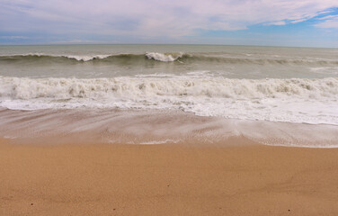 Spiaggia di sabbia con mare mosso. Mare con onde in inverno. - obrazy, fototapety, plakaty