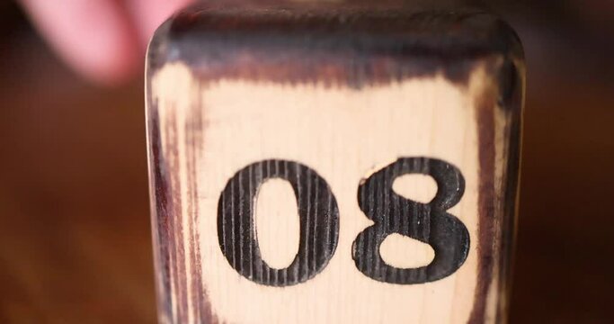 The number 08 on the wooden cube is burned with large symbols. 