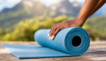 Close-up of woman roll blue yoga mat. Sport, yoga, fitness workout, active healthy lifestyle