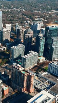 Downtown Atlanta Georgia aerial view. High skyscrapers, construction with cranes, autumn park. Sunny day. Aerial View Atlanta Buckhead. Vertical video.