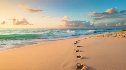 Fotobehang Sandy footprints leading towards the glistening ocean waters © Cloudyew