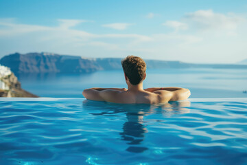 A man enjoys the serene view of a seascape from an infinity pool, embodying relaxation and luxury travel.