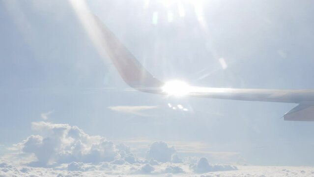 blue sky with white fluffy clouds from airplane flight fly over the clouds in a sunny day with cloud moving in summer