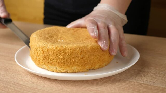 The freshly baked cake is cut in half for the filling. Cake making.