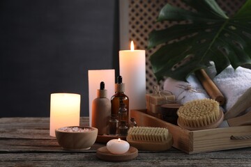 Fototapeta na wymiar Composition with different spa products and burning candles on wooden table