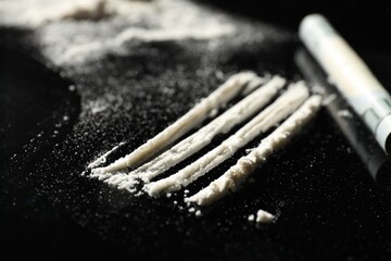 Drug addiction. Cocaine and rolled dollar banknote on black table, selective focus - obrazy, fototapety, plakaty