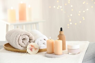 Fototapeta na wymiar Spa composition. Burning candles and personal care products on soft surface