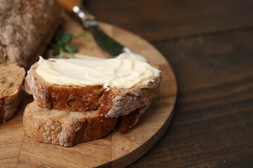 Slices of tasty bread with butter on wooden table, closeup, Space for text