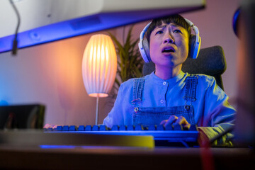 Gaming at Home: Gamer Frustrated by Losing a Round of Playing Online Video Game on Personal Computer. Saddened Female Playing RPG Strategy Arcade Online Multiplayer PvP Tournament. Evening at Home.