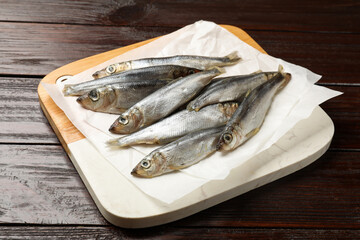 Fresh raw sprats on wooden table, closeup