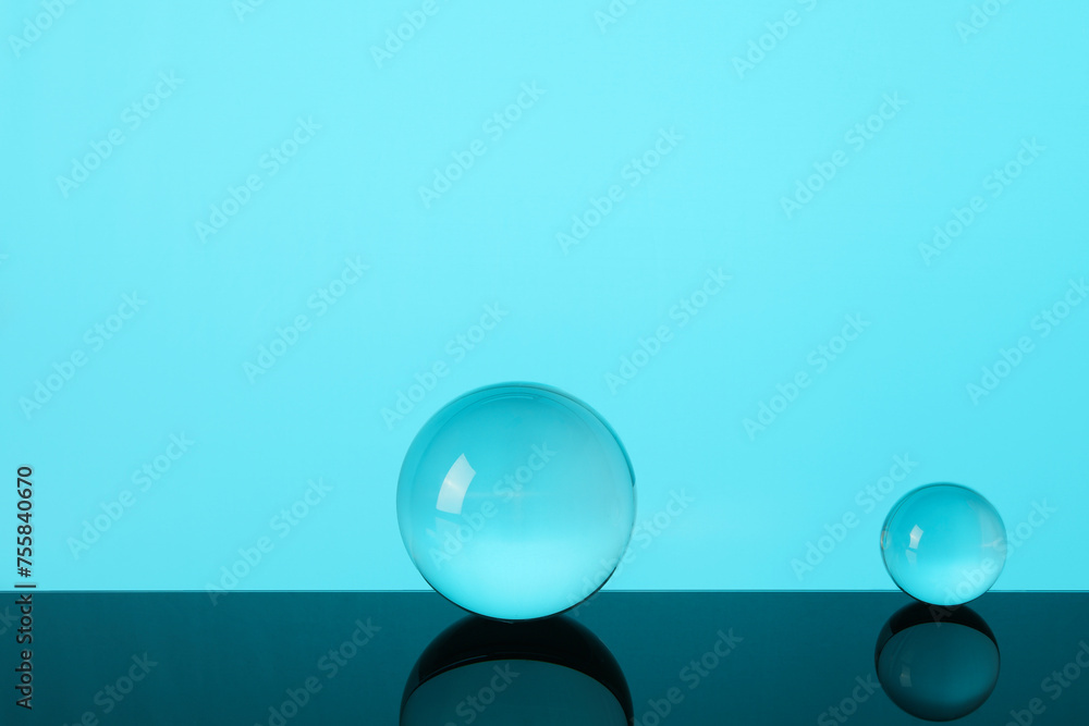 Canvas Prints Transparent glass balls on mirror surface against turquoise background. Space for text