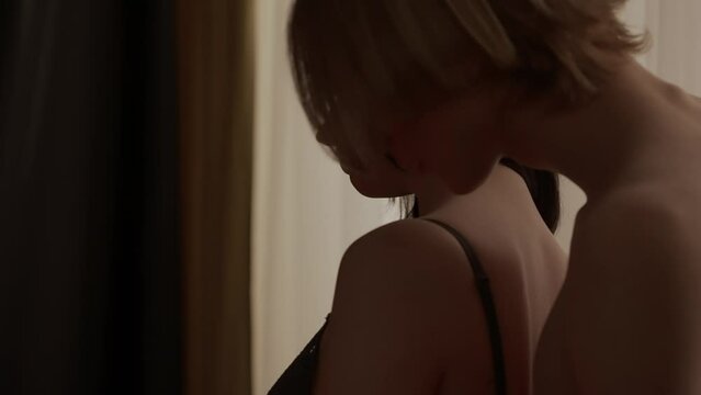 Young loving couple silhouettes in apartment. Man and woman sensual lovers faces close up shot, passion intimacy kissing, touching, attraction and desire.