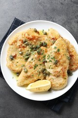Delicious chicken piccata with herbs on grey table, top view
