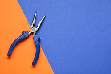 Needle nose pliers on color background, top view. Space for text